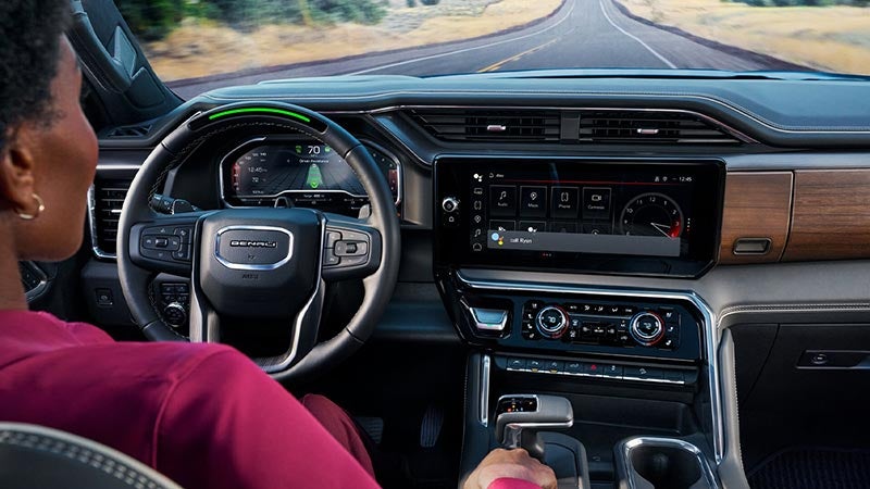 A driver sitting behind the wheel while Super Cruise controls the vehicle.